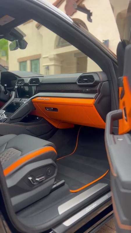 Interior naranja y negro de un Lamborghini Urus tras el detallado